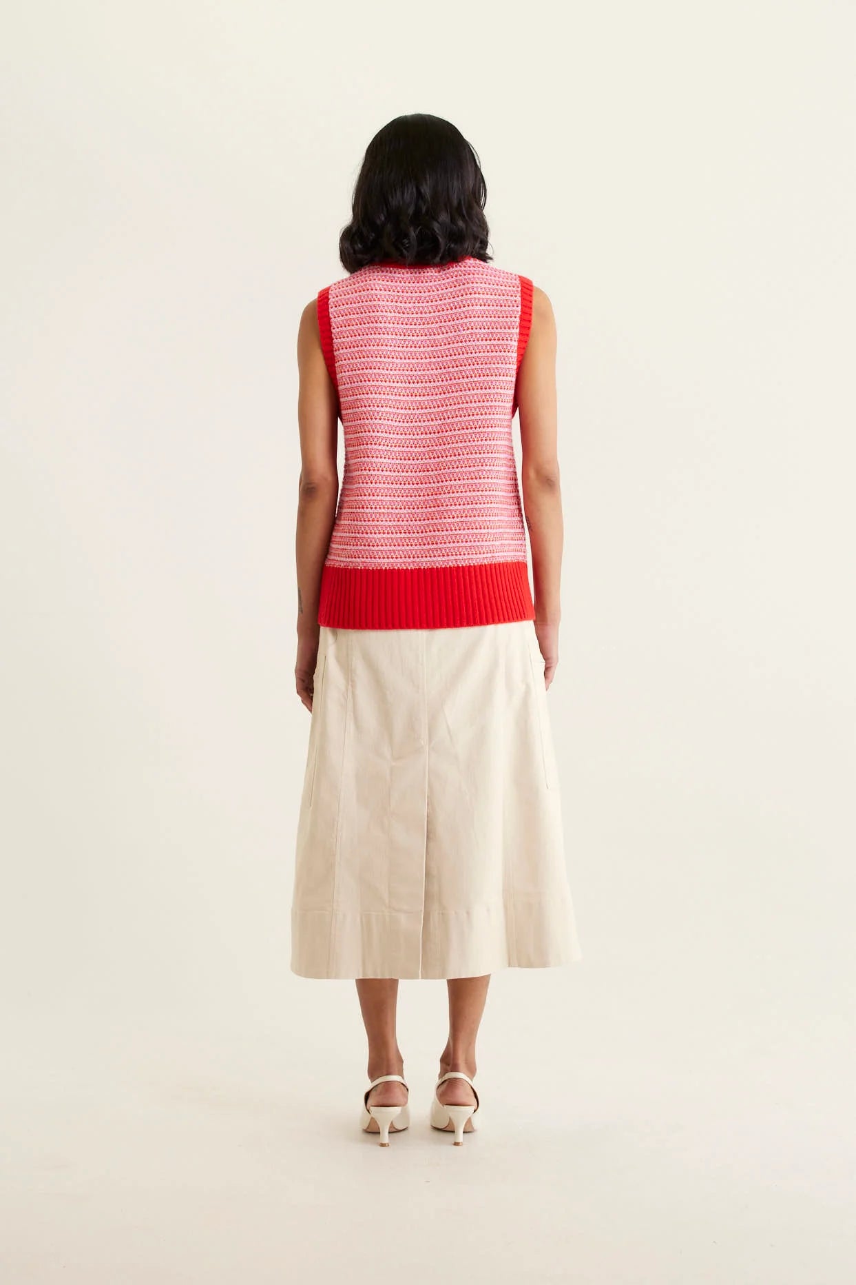 woman facing the back wearing Houston Merino Cashmere Vest - Red and beige skirt