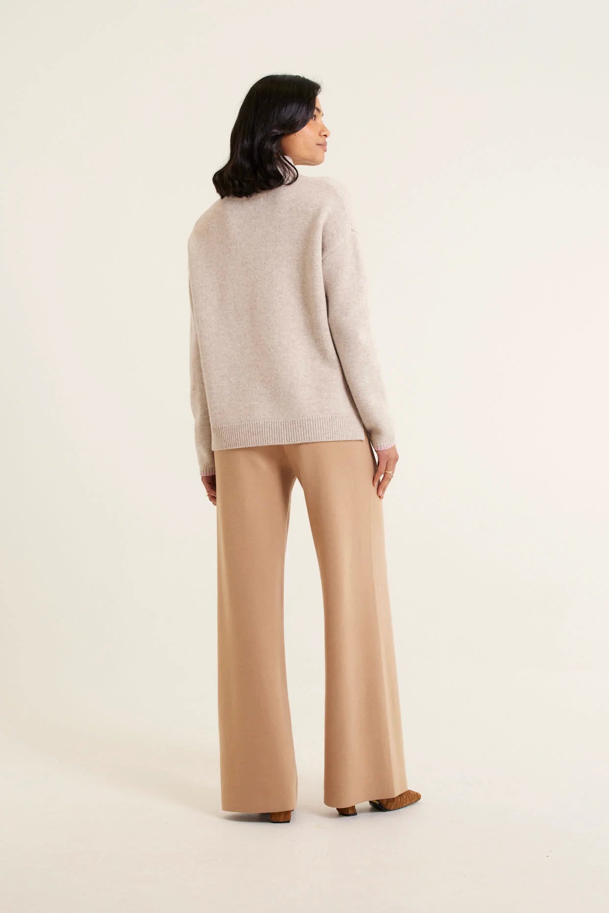 woman facing the backwearing Ronnie Merino Cashmere Polo - Beige and brown pants