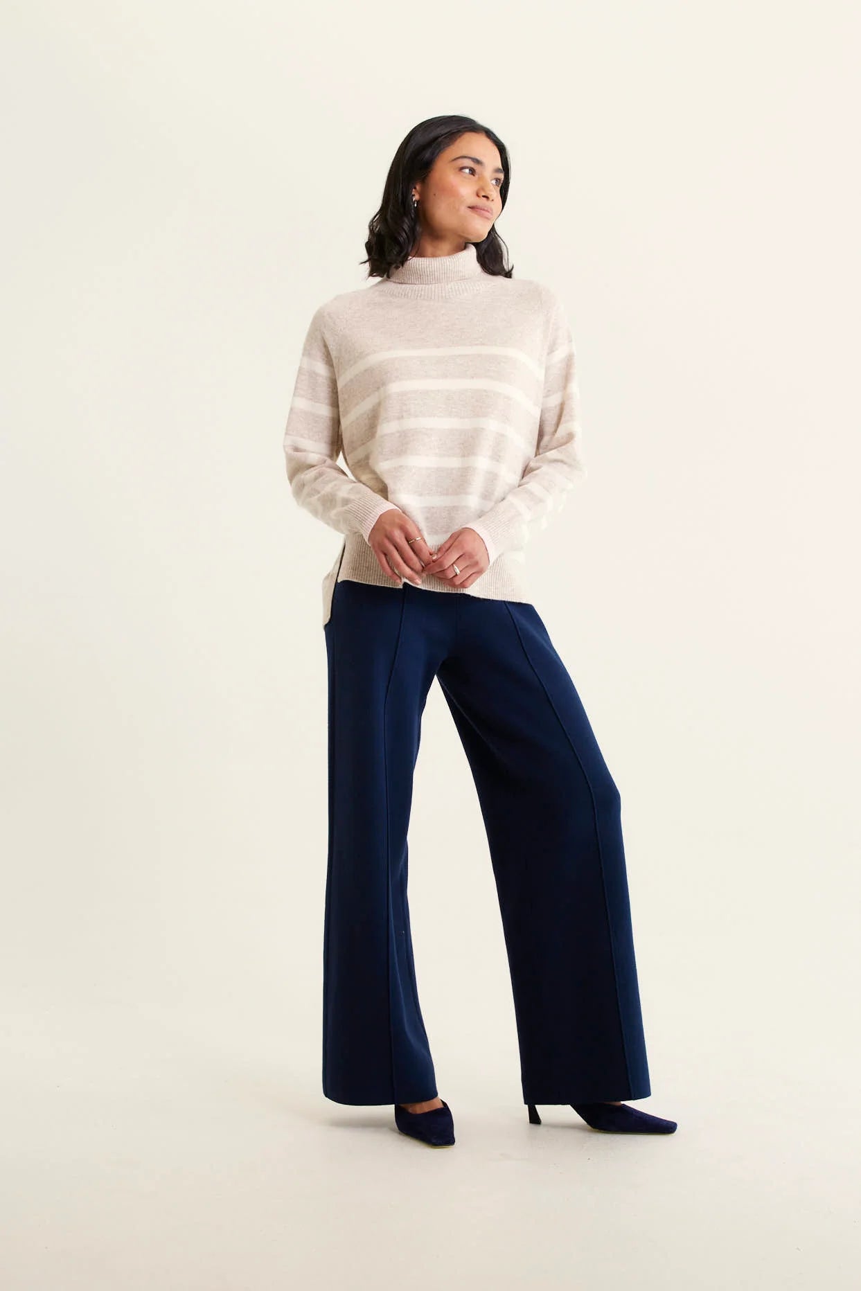 woman wearing Toastie Stripe Merino Cashmere Polo - Beige and navy pants