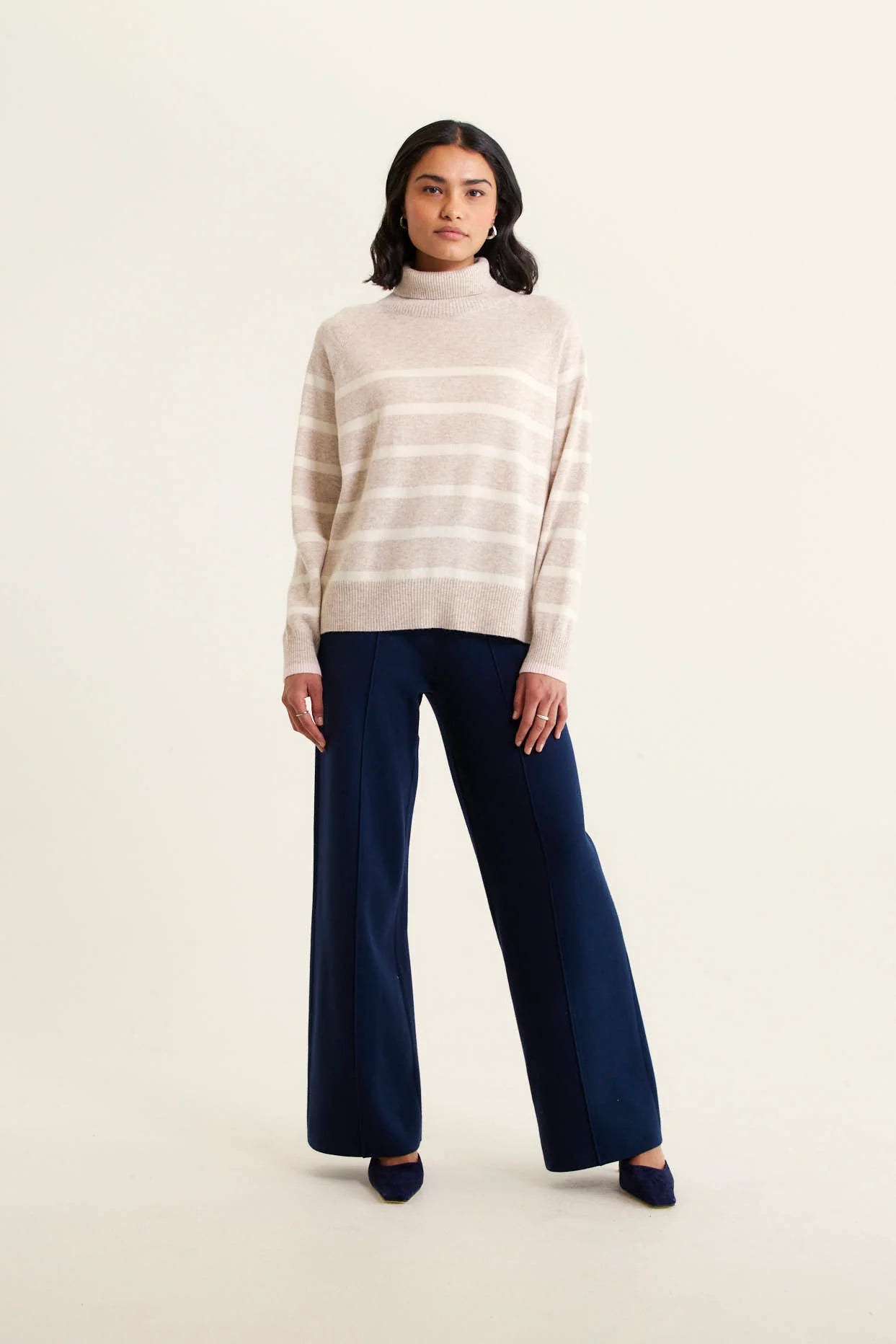 woman wearing Toastie Stripe Merino Cashmere Polo - Beige and navy pants