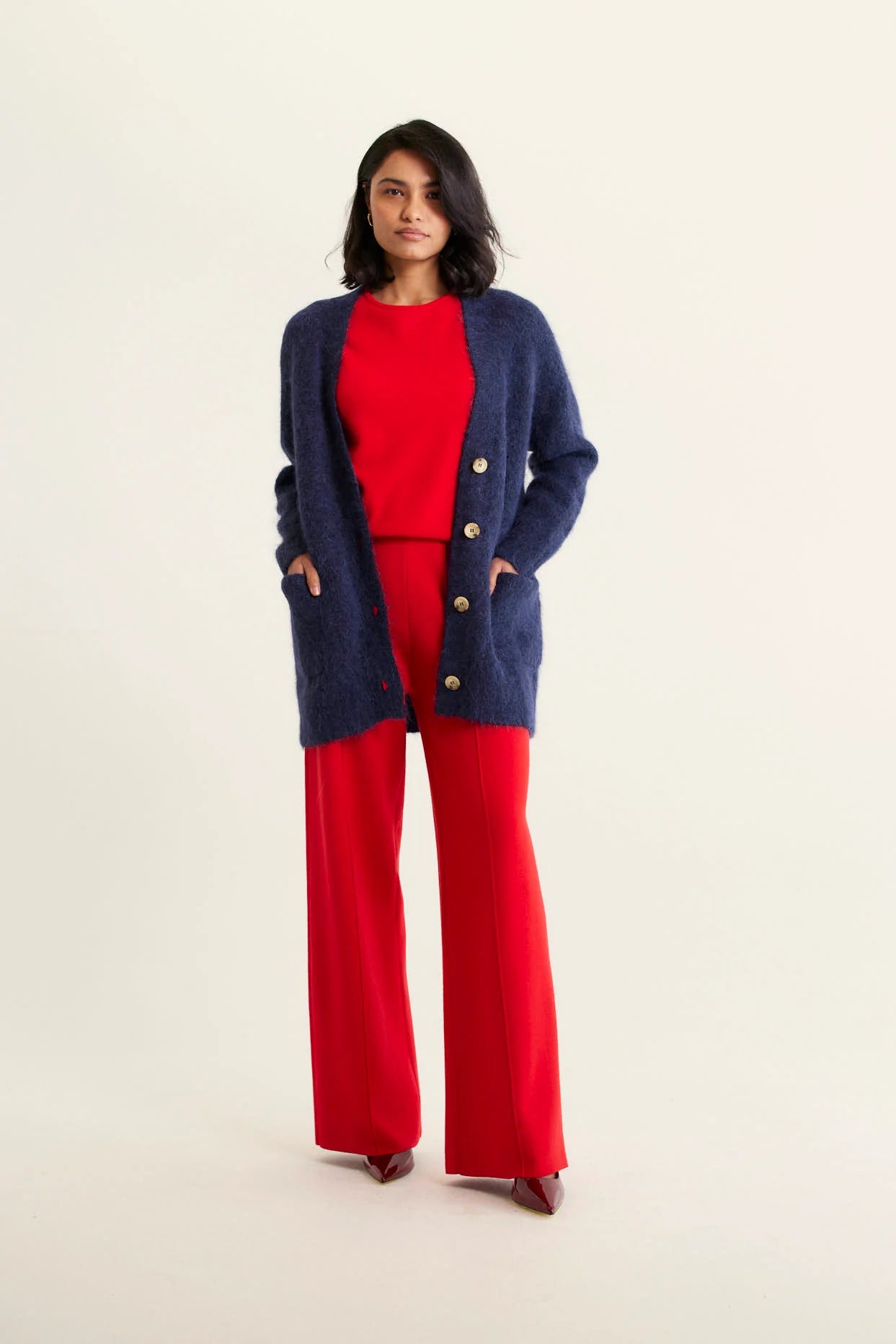 woman wearing red top and pants with Williamsburg Cardi - Navy