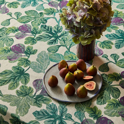 Plate of figs and a vase of flowers on a Figgy Green Round Tablecloth