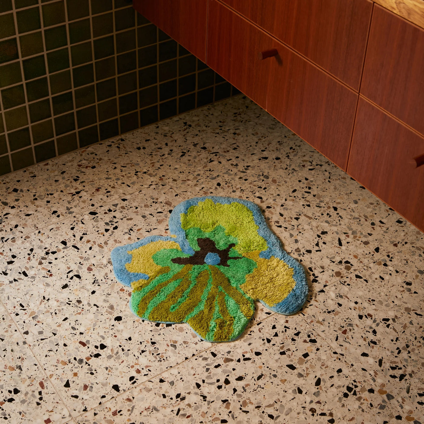 viola green small bath mat placed on terrazzo bathroom floor 