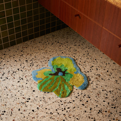 viola green small bath mat placed on terrazzo bathroom floor 
