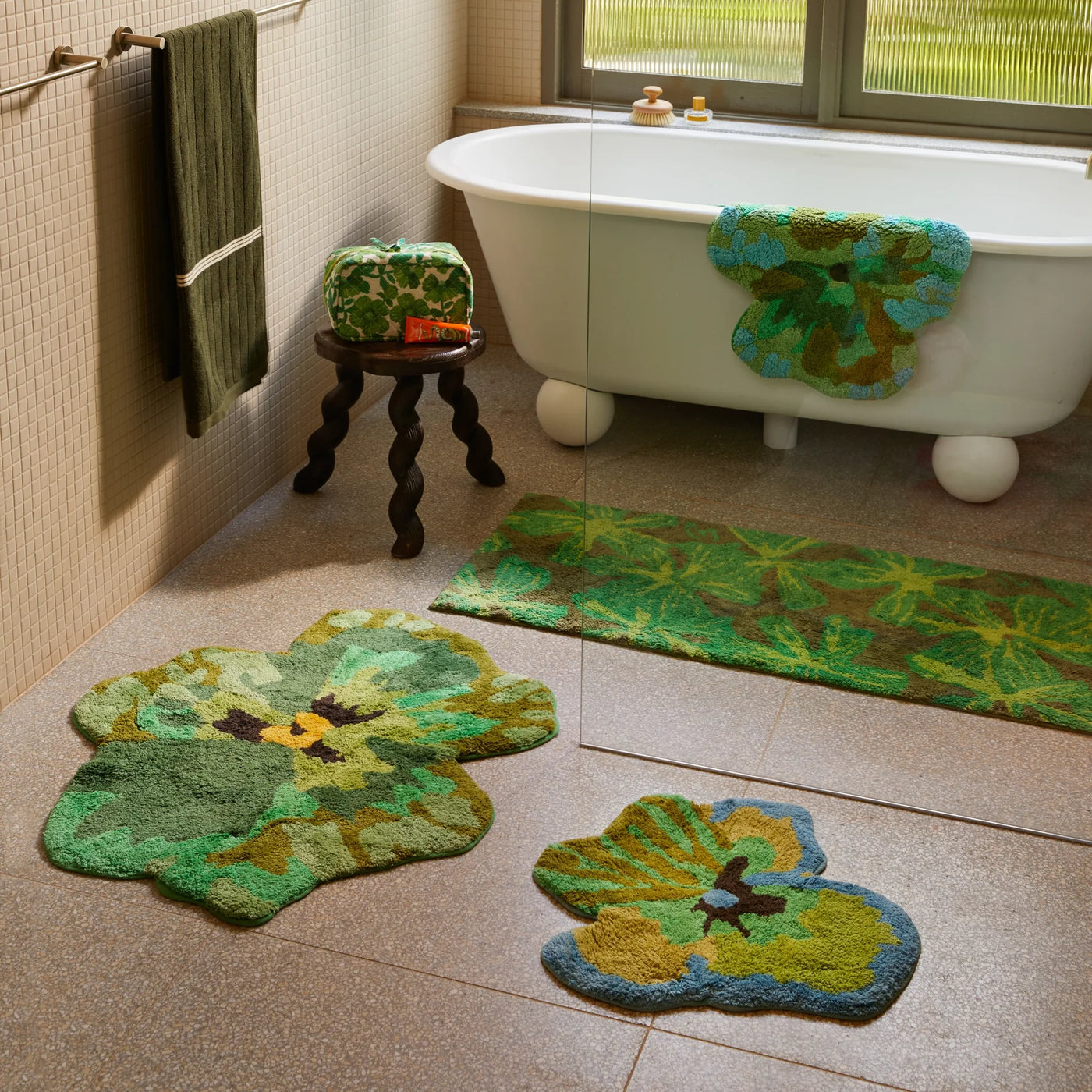 Bathroom with a white freestanding bathtub, pansy, viola green small bath mat, green and yellow bath mats on the floor