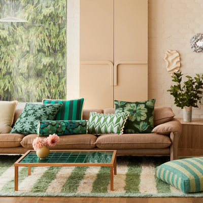 Living room with green floral and stripe cushion placed in brown sofa
