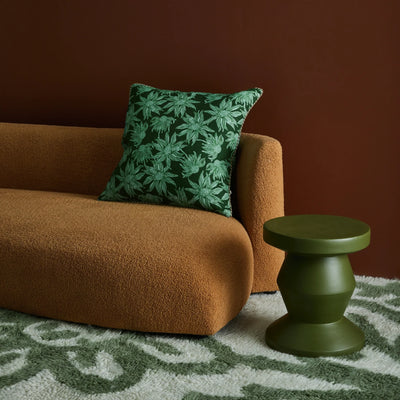 green floral cushion placed in brown sofa