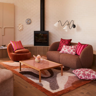Living room with Pink flannel flower and bold stripe cushion placed on the brown sofa