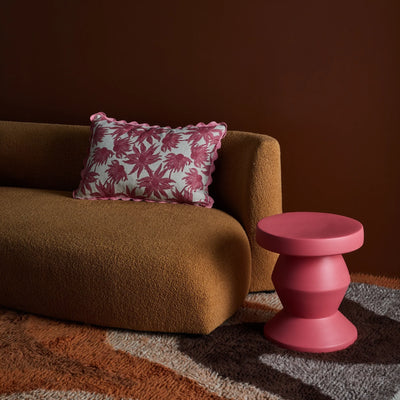 Pink Flannel flower cushion placed in brown sofa