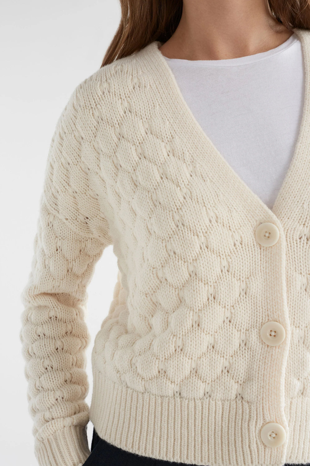 Woman wearing black pants, white top with emmer cardigan in oatmeal colour