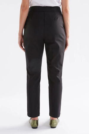 Woman facing the back wearing white shirt and black pants