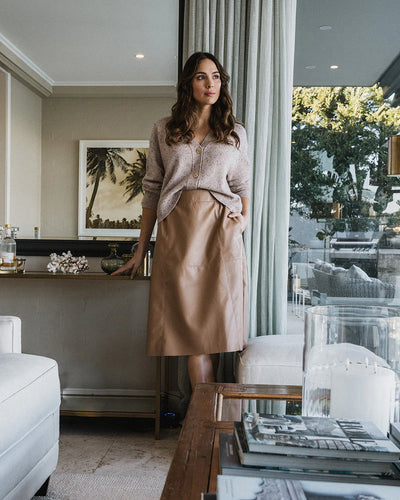 Woman wearing cardigan in strawberry and copper row skirt in tan