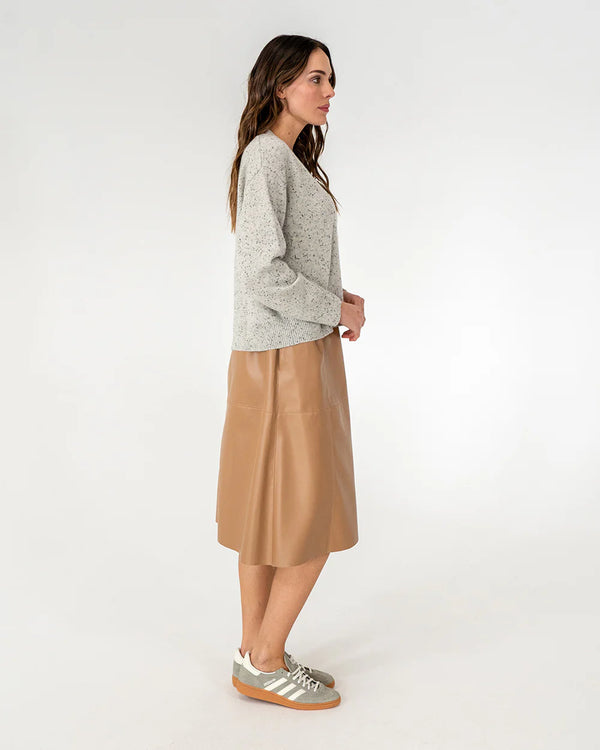 Woman wearing cardigan in oreo and copper row skirt in tan side view