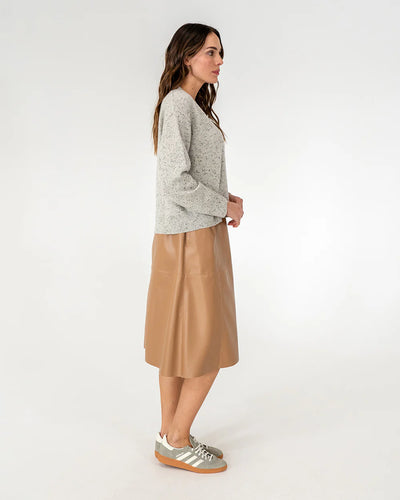 Woman wearing cardigan in oreo and copper row skirt in tan side view