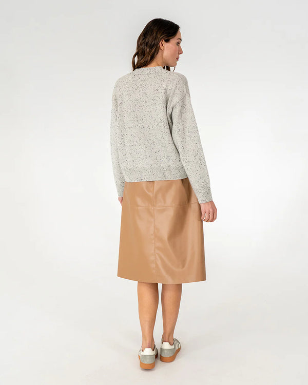 Woman wearing cardigan in oreo and copper row skirt in tan back view