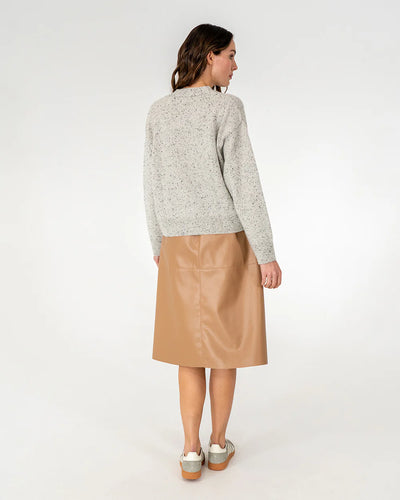 Woman wearing cardigan in oreo and copper row skirt in tan back view