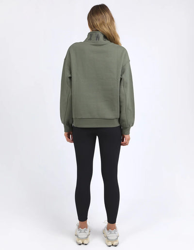 Woman facing the back wearing college zip crew khaki and black leggings