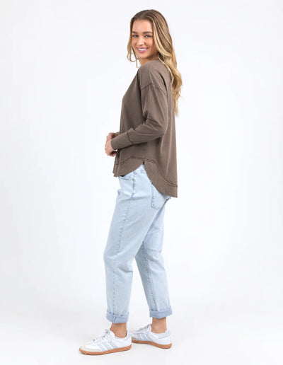 Woman facing slightly the side wearing Farrah Long Sleeve - Coffee Quartz and light denim pants
