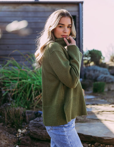 Woman wearing Jude Knit in Olive Green and light denim pants