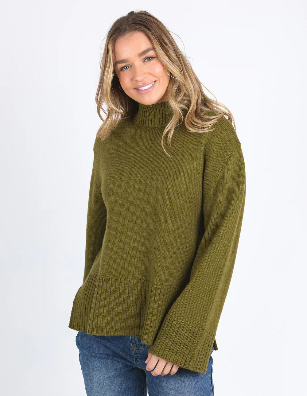 Woman wearing Jude Knit in Olive Green and light denim pants
