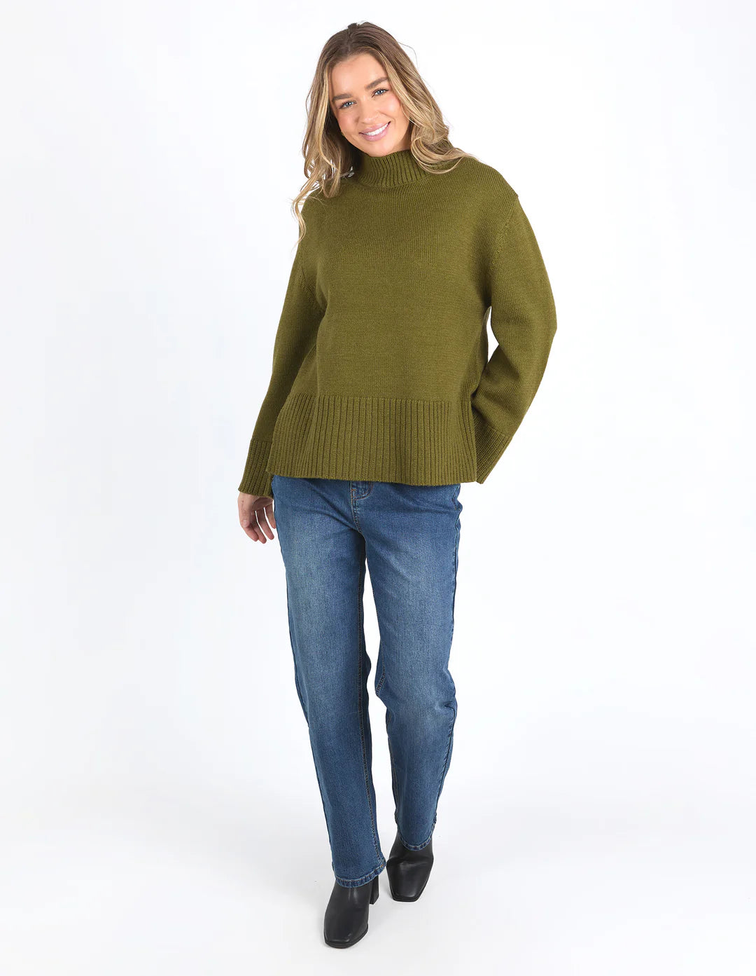 Woman wearing Jude Knit in Olive Green and dark denim pants, facing the front