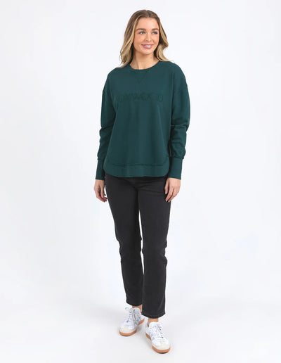 Woman wearing Simplified Crew - Forest and black pants