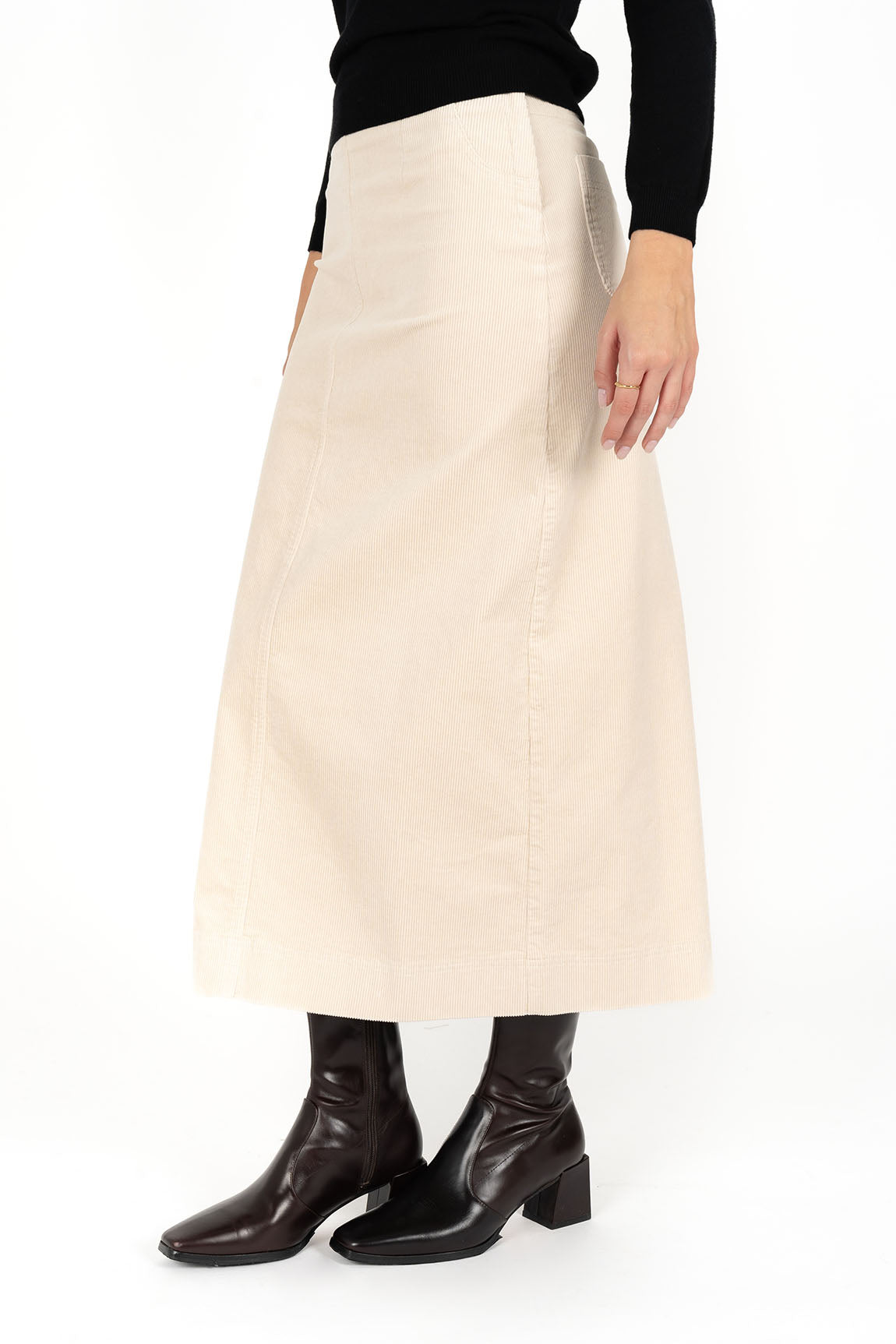 Woman wearing black long sleeve top and Billie Cord Maxi Skirt in Vanilla and black boots side view