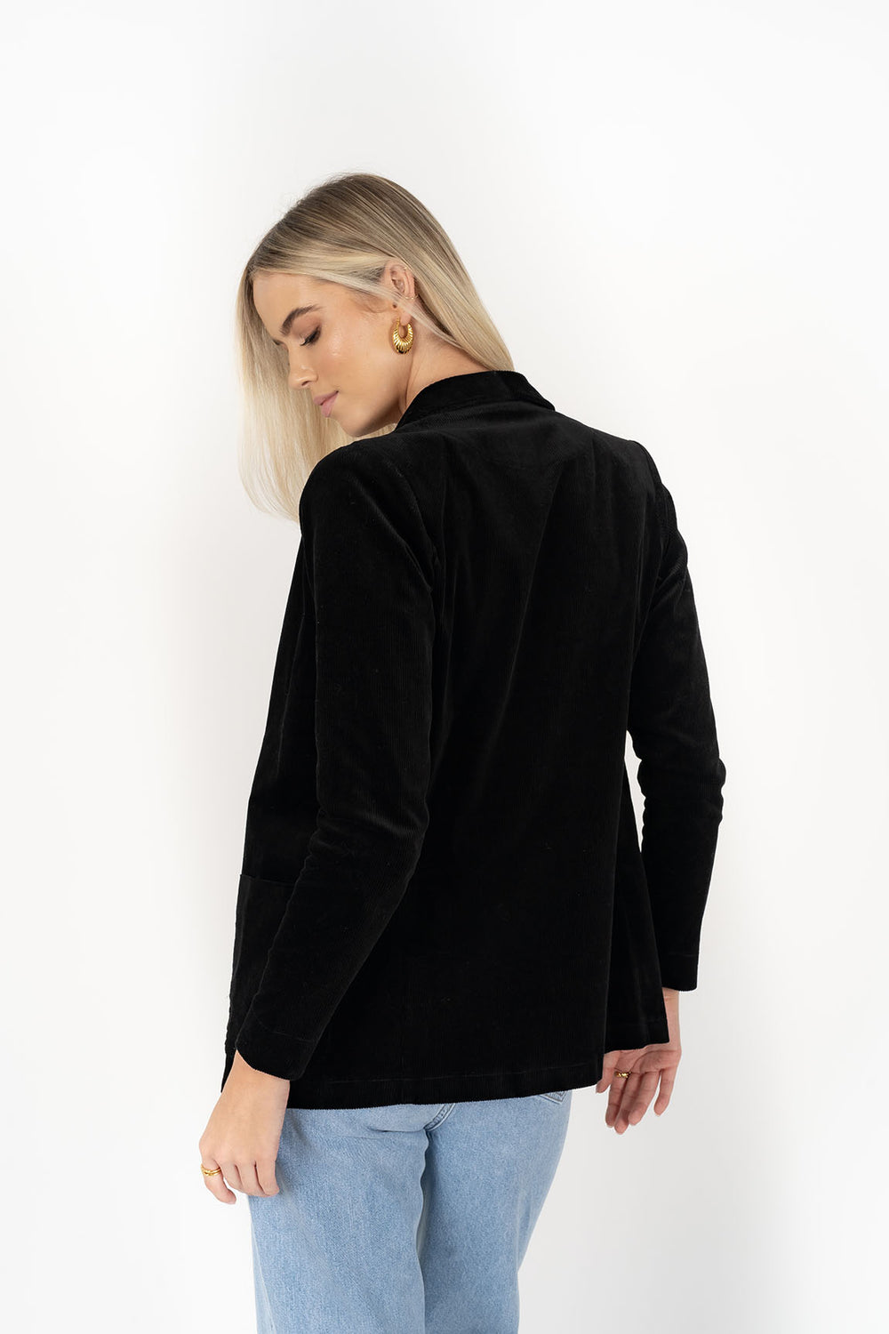 Woman wearing cream top with Blondie Jacket in Midnight and Light blue pants