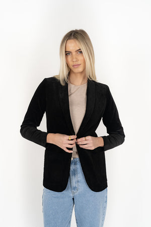 Woman wearing cream top with Blondie Jacket in Midnight and Light blue pants