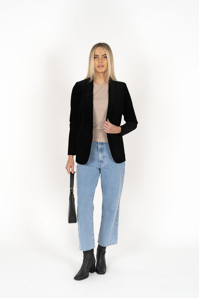 Woman wearing cream top with Blondie Jacket in Midnight and Light blue pants
