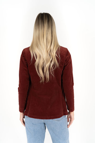 Woman wearing Blondie Jacket in Rust colour and light blue denim pants back view