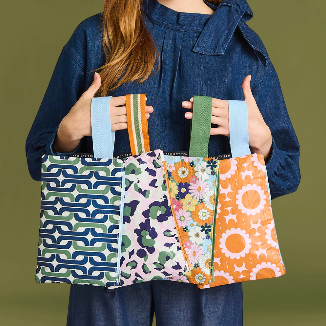 Person holding mini zip pouch in different patterns