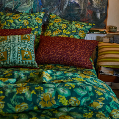 Bed with green floral bed cover, pillowcase, and odette linen pillowcase