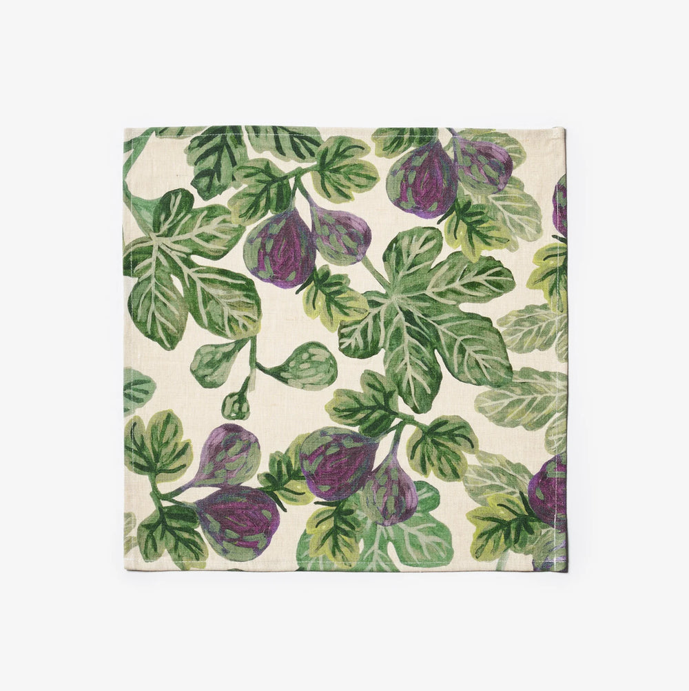 Figs resting on a fig-patterned tablecloth and figgy green napkins set