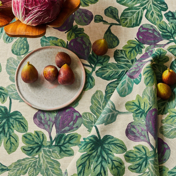 Figs resting on a fig-patterned tablecloth and figgy green napkins set