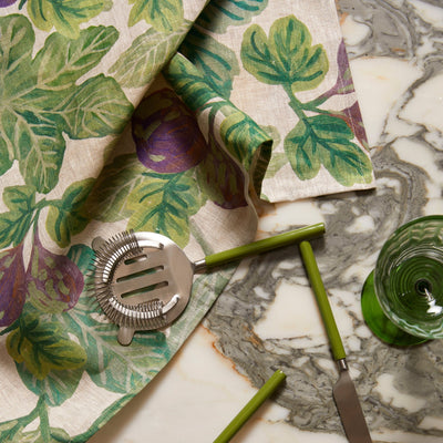 figgy green tea towel hanging with mint green utensils above a marble countertop.