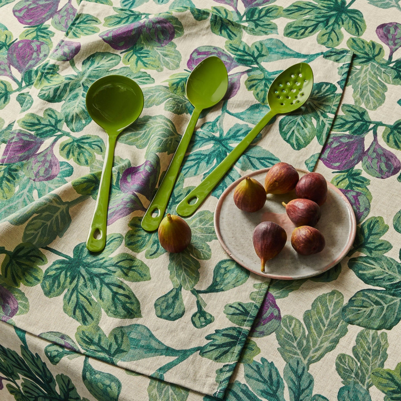 figgy green table cloth and figgy green tea towel with mint green utensils above a table