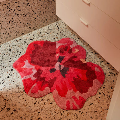 pansy bath mat placed on terrazzo bathroom floor next to a white cabinet with drawers