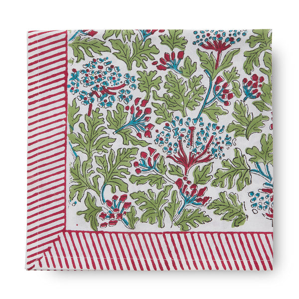 folded canvas and sasson tableau joy tablecloth features a continuous floral design in scarlet red, sky blue and fern on a white base, finished with a scarlet red and white striped border.
