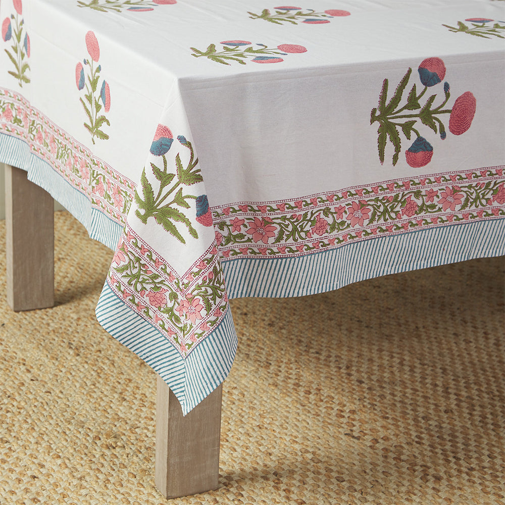 table with canvas and sasson tableau tablecloth in Pink features a large Mughal poppy print in hues of pinks, greens and blues on a white cotton base, finished with a beautifully ornate flowing border and striped edge.