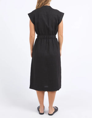 woman facing the back wearing foxwood harlow dress in black, and black slip on slipper