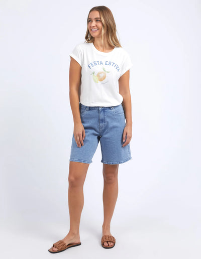 woman wearing foxwood italian summer tee vintage in white, denim short, and brown slip on slippers