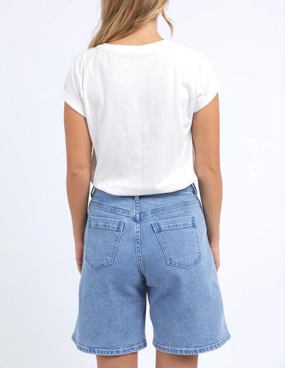 woman facing the back wearing foxwood italian summer tee vintage in white, denim short