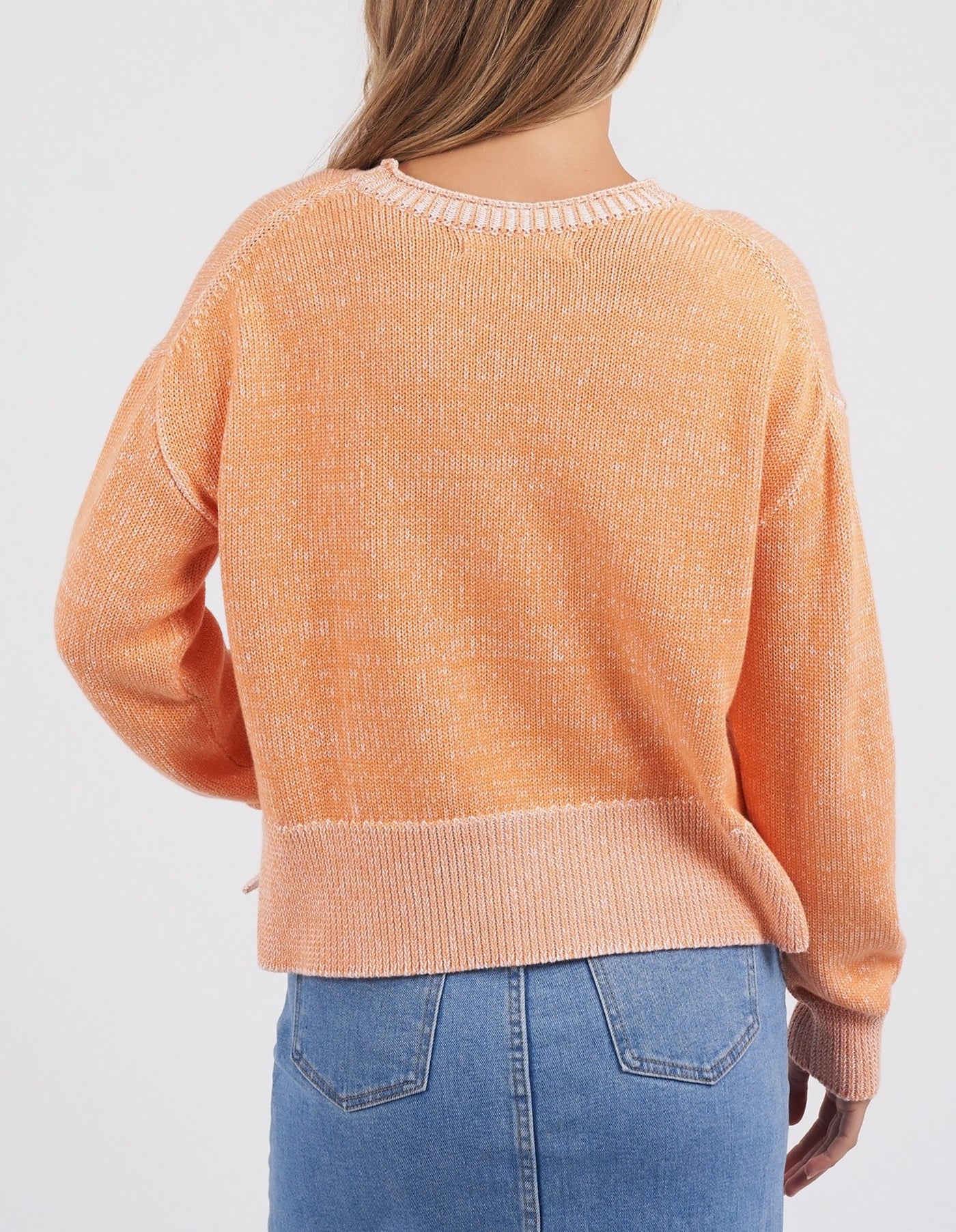 woman facing the back wearing foxwood wrenley knit tangerine and denim skirt