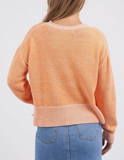woman facing the back wearing foxwood wrenley knit tangerine and denim skirt
