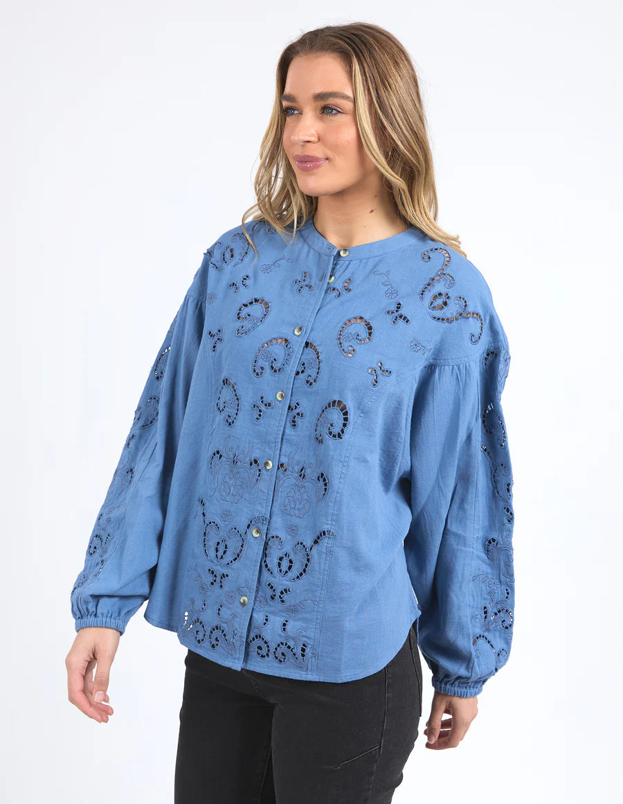 Woman wearing long sleeve blue marlow blouse and black pants
