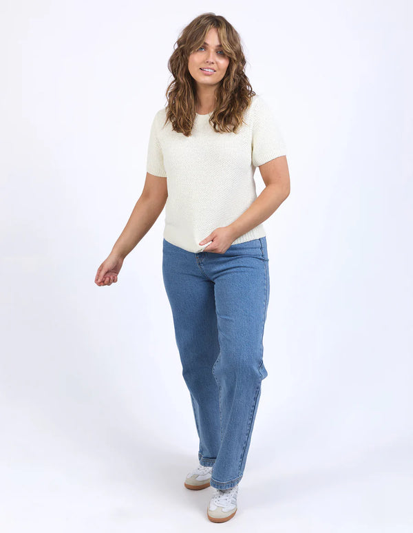 Woman wearing Blair Short Sleeve Knit Vintage White and denim pants