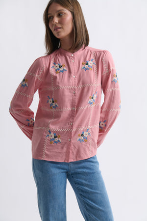 Kireina Carol Shirt in Musk Pink – full-length ecom shot, model wearing the floral-embroidered musk pink shirt with blue jeans, showing the button-up front and white broderie trim, on a white background