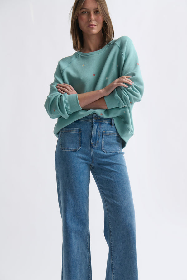 Full-length front ecom shot of Patti Sweatshirt Daisy Mint Green showing relaxed fit and ribbed waistband styled with wide-leg jeans on white background