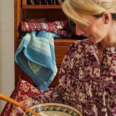 woman near the cabinet with Brigitte Tea Towel in Jade and mitt